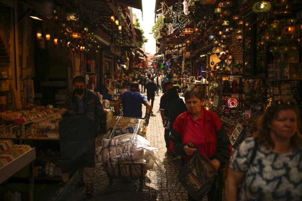 People walk along a street market in Eminonu commercial area a day after the presidential election day, in Istanbul, Turkey, Monday, May 15, 2023. Turkey's presidential elections appeared to be heading toward a second-round runoff on Monday, with President Recep Tayyip Erdogan, who has ruled his country with a firm grip for 20 years, leading over his chief challenger, but falling short of the votes needed for an outright win. (AP Photo/Emrah Gurel)