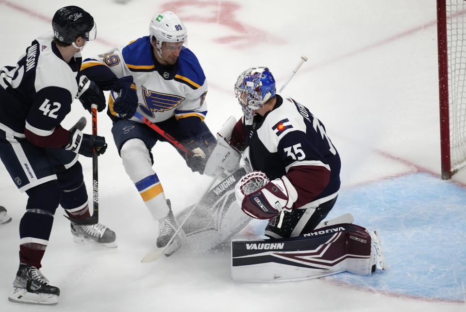 St. Louis Blues left wing Pavel Buchnevich, center, has his shot stopped by Colorado Avalanche goaltender Darcy Kuemper, right, after driving past defenseman Josh Manson in the first period of an NHL hockey game Tuesday, April 26, 2022, in Denver. (AP Photo/David Zalubowski)