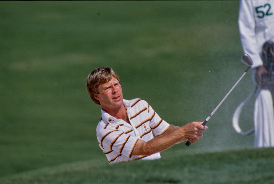 Ben Crenshaw hits ball from bunker at the Augusta National Golf Course on April 15, 1984 during the Masters Tournament.