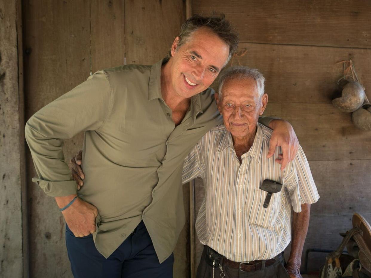 Dan Buettner standing with a centenarian.