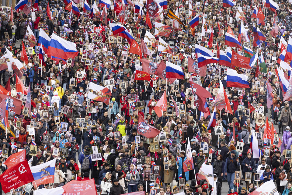 People attend the Immortal Regiment march through the main street toward Red Square marking the 77th anniversary of the end of World War II, in Moscow, Russia, Monday, May 9, 2022. (AP Photo/Denis Tyrin)