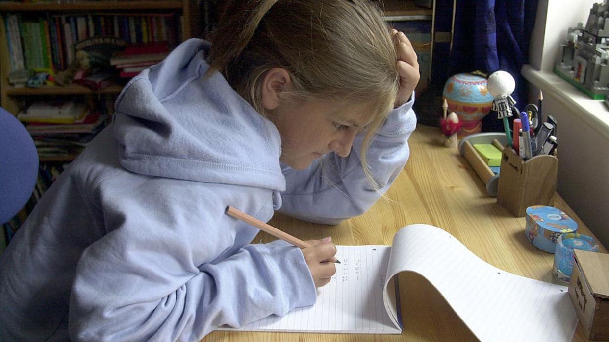 <div>Teenage girl doing homework at desk in bedroom.. (Photo by Jeff Overs/BBC News & Current Affairs via Getty Images)</div>