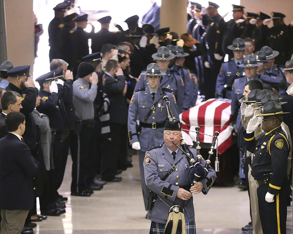 Americus police officers salute the casket of fallen police officer Nicholas Ryan Smarr at his funeral service at the Georgia Southwestern State University Storm Dome on Sunday, Dec. 11, 2016, in Americus, Ga. Smarr and his lifelong friend, Georgia Southwestern State University campus police officer Jody Smith, were killed responding to a domestic violence call on Wednesday. (Curtis Compton/Atlanta Journal-Constitution via AP)