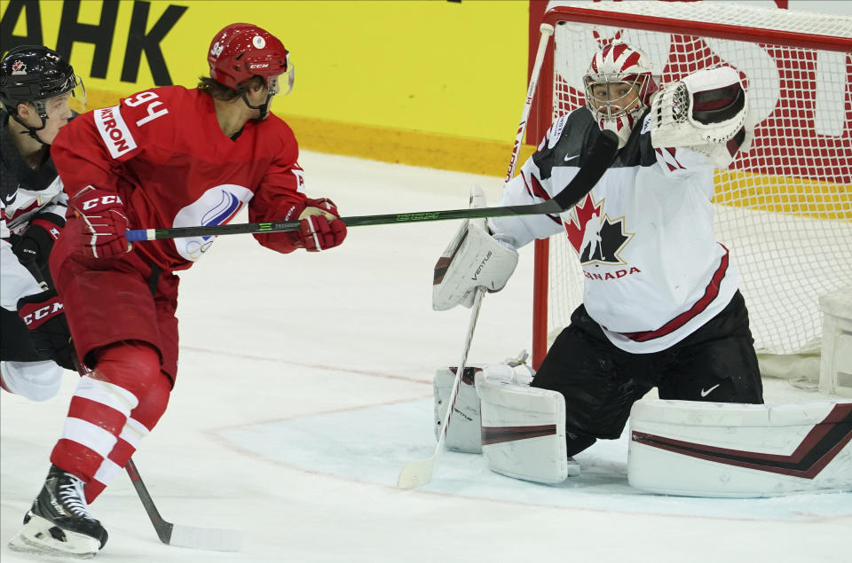 Alexander Barabanov of Russia, left, fight for a puck with Darcy Kuemper of Canada during the Ice Hockey World Championship quarterfinal match between Russia and Canada at the Olympic Sports Center in Riga, Latvia, Thursday, June 3, 2021. (AP Photo/Roman Koksarov)