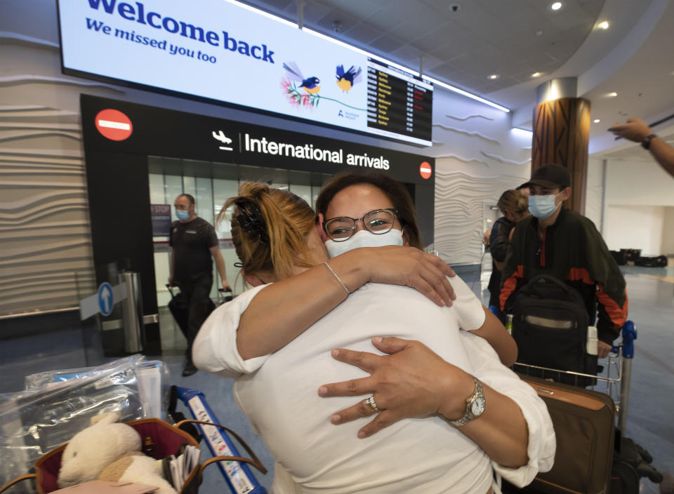 Two women embrace after one arrives on a flight from Australia at Auckland International Airport, Auckland, New Zealand on Feb. 26, 2022. New Zealand is ending a requirement that incoming travelers isolate themselves as it continues to dismantle its coronavirus border protections in the face of a growing domestic outbreak. (Brett Phibbs/New Zealand Herald photograph via AP)