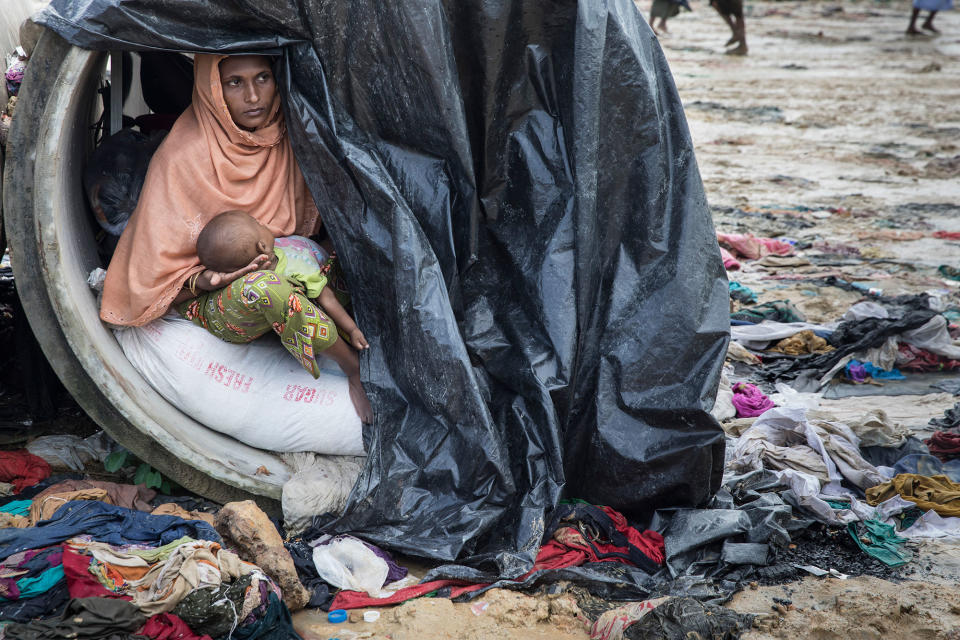 <p>Sameera, 20, looks out from a cement cylinder holding her 7 month old baby where the family are living until a shelter is built, on September 17, 2017, in Kutupalong, Cox’s Bazar, Bangladesh. (Photograph by Paula Bronstein/Getty Images) </p>