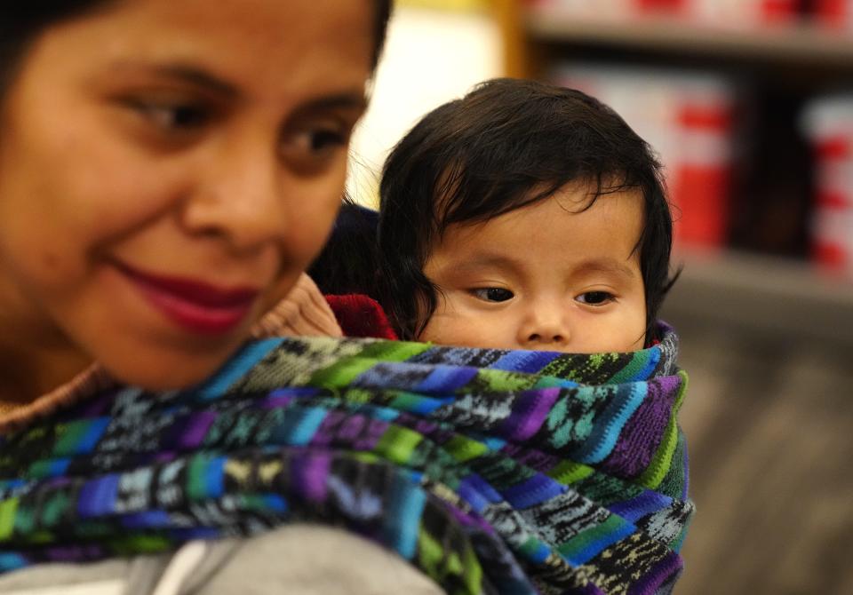 Matilde Hernandez carries her child with her as she shops during a $1,000 shopping spree for poverty-level families at Target.