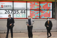 People walk by an electronic stock board of a securities firm in Tokyo, Wednesday, Dec. 2, 2020. Asian markets are mixed after the U.S. benchmark S&P 500 set another record. (AP Photo/Koji Sasahara)