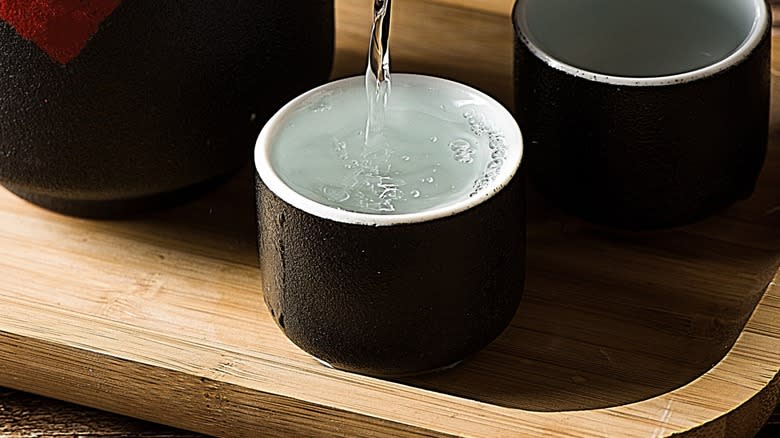 Closeup of clear alcohol being poured into a small cup