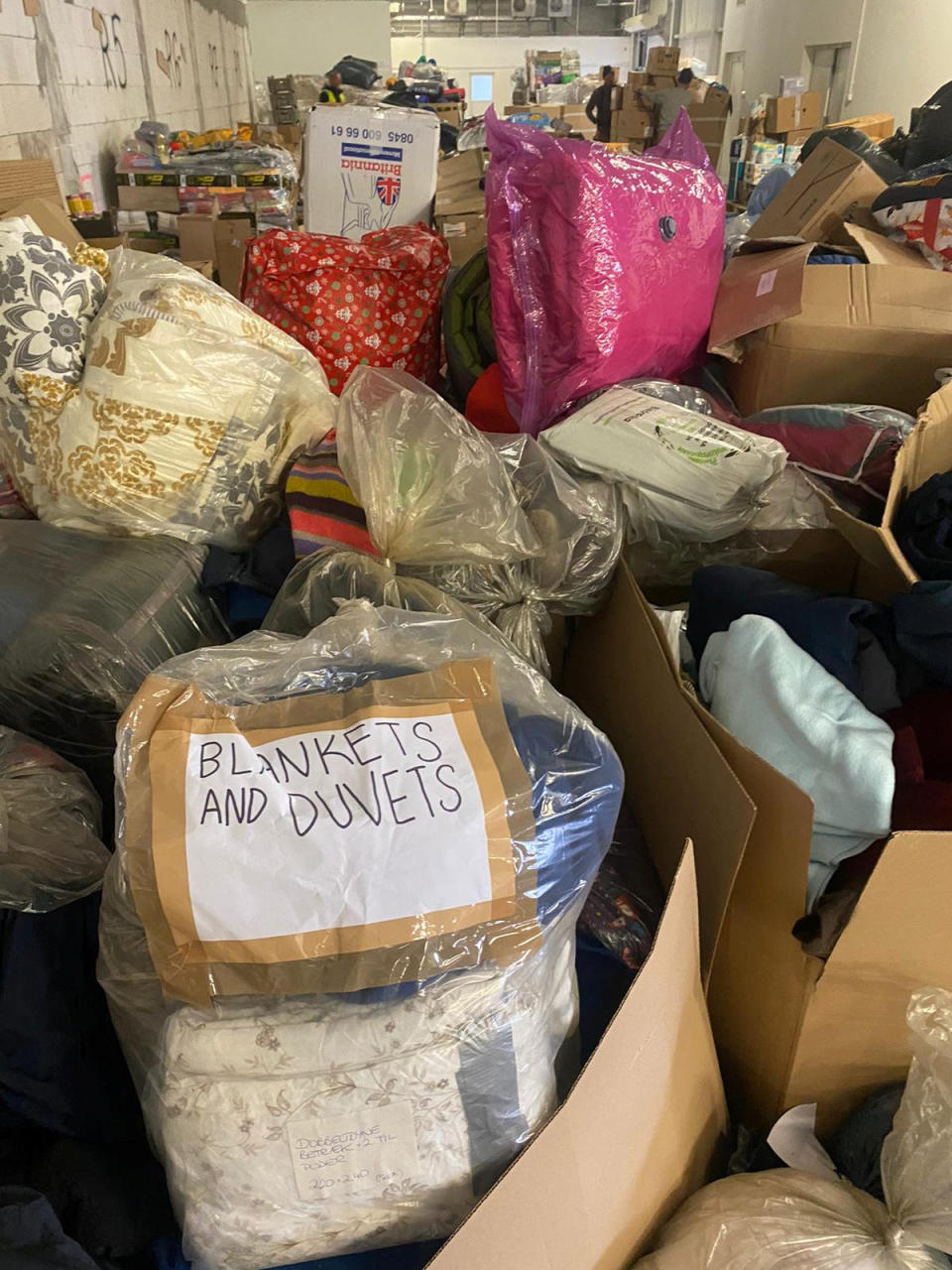 Huge mounds of clothing and bedding donated by well-meaning Europeans have been dumped and abandoned in a car park on the Polish-Ukrainian border (SWNS)