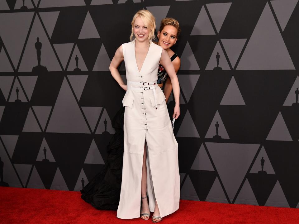 Jennifer Lawrence hides behind Emma Stone on the red carpet at the Governors Awards in 2017.