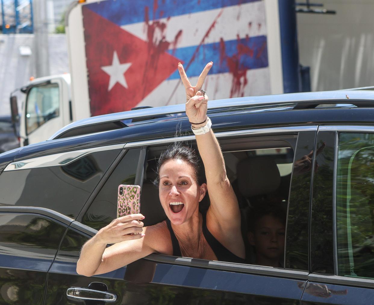 A woman screams out her window in support of people at West Palm Beach City Hall taking part in a July 18 rally to support anti-government protesters in Cuba.