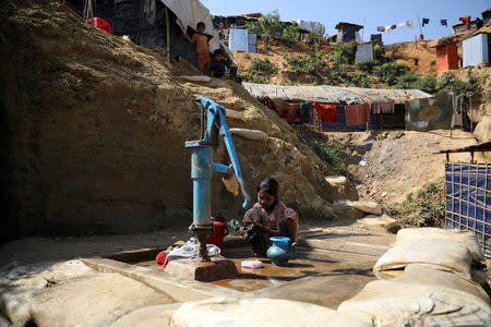 A Rohingya girl washes clothes with tube-well water at Balukhali refugee camp in Cox's Bazar, Bangladesh, January 20, 2018. REUTERS/Mohammad Ponir Hossain