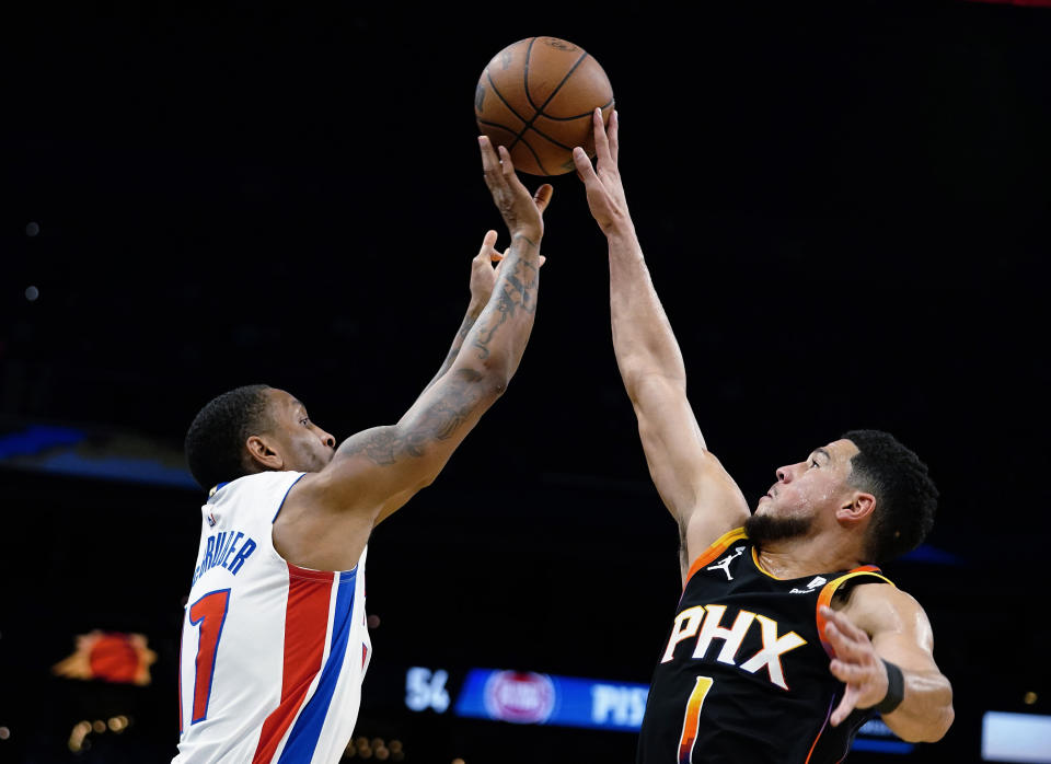 Phoenix Suns' Devin Booker (1) blocks a shot from Detroit Pistons' Rodney McGruder (17) during the first half of an NBA basketball game in Phoenix, Friday, Nov. 25, 2022. (AP Photo/Darryl Webb)