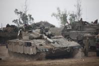 ISRAEL/GAZA BORDER, ISRAEL- NOVEMBER 19: (ISRAEL OUT) An Israeli soldier directs a tank in a deployment area on November 19, 2012 on Israel's border with the Gaza Strip. The death toll has risen to at least 85 killed in the air strikes, according to hospital officials, on day six since the launch of operation 'Pillar of Defence.' (Photo by Uriel Sinai/Getty Images)