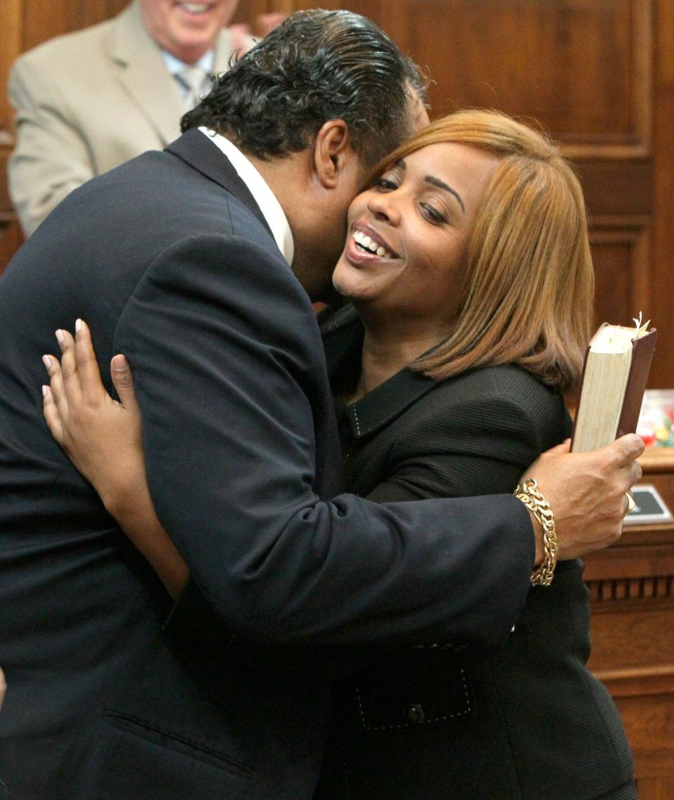 Former Akron City Council President Marco Sommerville gives his daughter Margo a hug after she took the oath of office to fill his Ward 3 seat on council in January 2013.