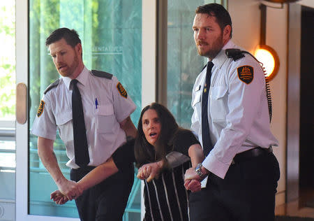 Security guards hold a protester as they remove a group from the House of Representatives after they began chanting slogans regarding the offshore detention of asylum seekers during Question Time in Parliament House, Canberra, Australia, November 30, 2016. AAP/Mick Tsikas/via REUTERS