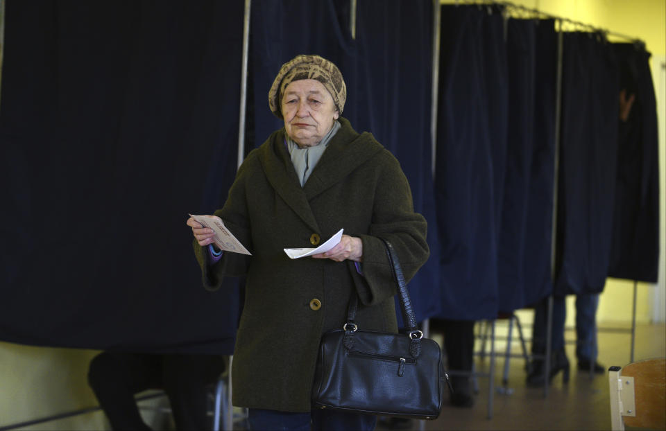 A Latvian woman holds her ballot papers at a polling station in Riga, Latvia, Saturday, Oct. 6, 2018. Latvians were casting their ballots on Saturday in a parliamentary election in which a party catering to the Baltic nation's large ethnic-Russian minority is expected to win the most votes, but is seen to be struggling to find coalition partners. (AP Photo/Roman Koksarov)