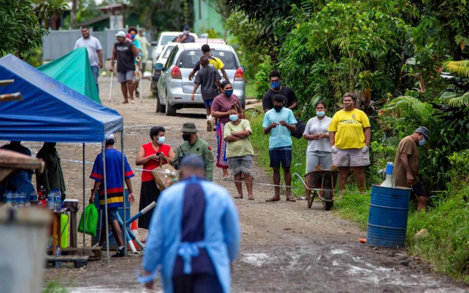 Residents look on as police check people are wearing face masks in Suva on July 3, 2021, as a worsening outbreak of the Covid-19 coronavirus Delta variant has overwhelmed the South Pacific nation's largest hospital - AFP