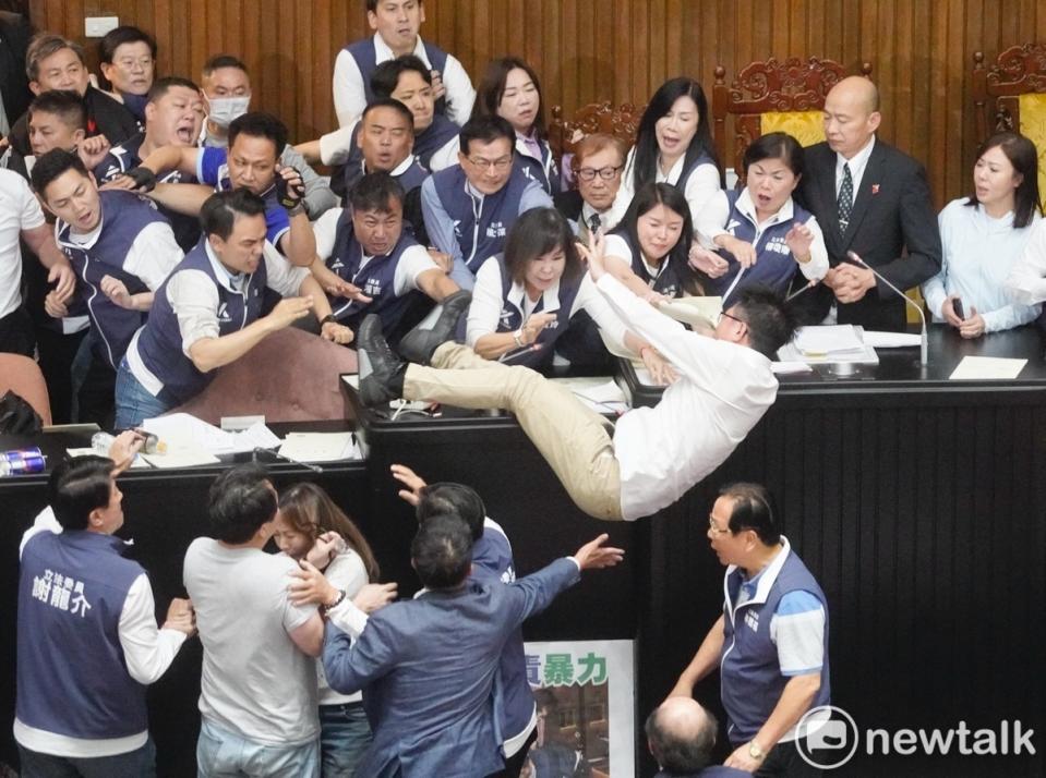 民進黨立委郭國文採桌上前進，不幸因推擠摔落。   圖：張良一/攝