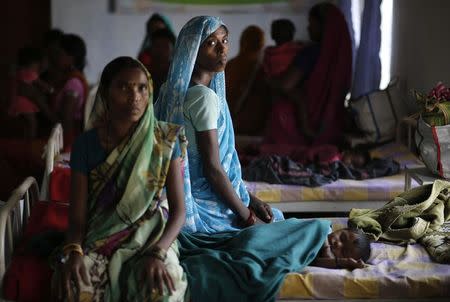 Kekti Bai (C), who underwent a sterilisation surgery at a government mass sterilisation camp, watches while other women sit inside a hospital at Bilaspur district in Chhattisgarh November 15, 2014. REUTERS/Anindito Mukherjee