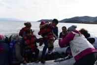 Refugees and migrants arrive with a dinghy at the village of Skala Sikaminias, on the Greek island of Lesbos, after crossing the Aegean sea from Turkey, on Friday, Feb. 28, 2020. An air strike by Syrian government forces killed scores of Turkish soldiers in northeast Syria, a Turkish official said Friday, marking the largest death toll for Turkey in a single day since it first intervened in Syria in 2016. (AP Photo/Micheal Varaklas)