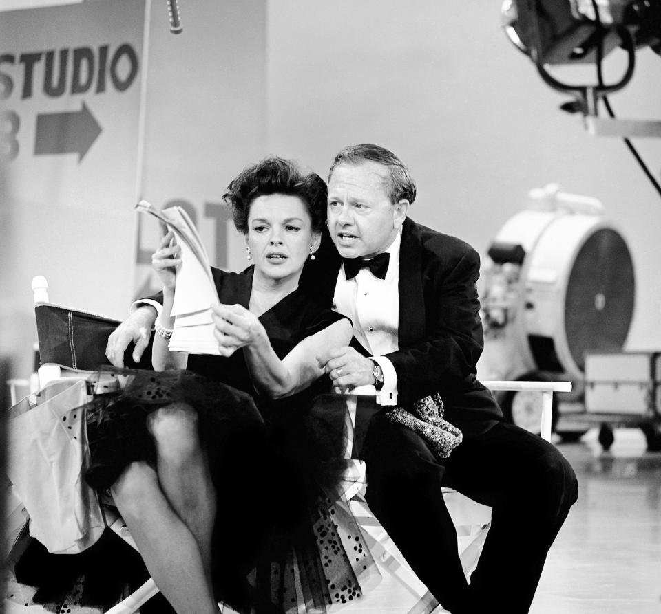 FILE - In this June 26, 1963, file photo, Judy Garland and Mickey Rooney put their heads together over a television script for their first onstage reunion in 18 years, for the taping of the first of 32 variety shows which Garland will do for CBS next season. Rooney, a Hollywood legend whose career spanned more than 80 years, died Sunday, April 6, 2014, at his North Hollywood, Calif. home. He was 93. (AP Photo/File)