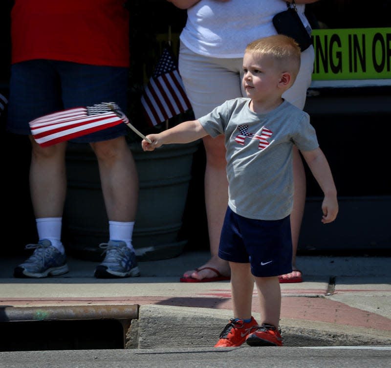 Cole Dostert, then 2, of Carleton waves a flag at a past Memorial Day Parade in Monroe.