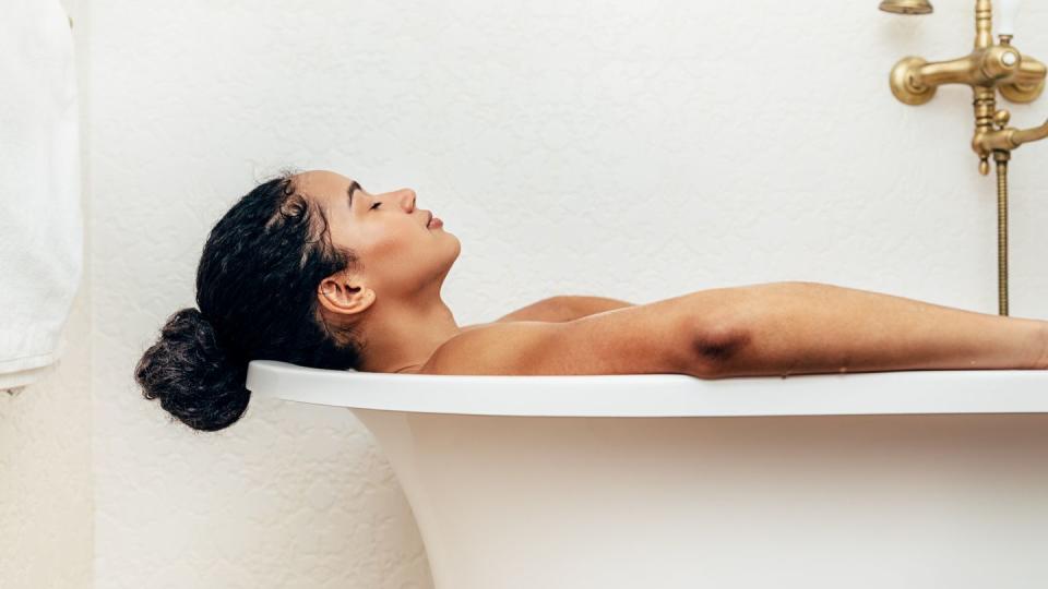 side view of young woman having a bath