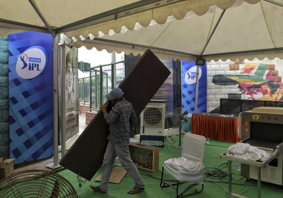 A worker carries a part of body scanner after dismantling it at the entrance of Arun Jaitley Stadium, one of the six venues of Indian Premier League 2021, in New Delhi, India, Tuesday, May 4, 2021. The Indian Premier League was suspended indefinitely on Tuesday after players or staff at three clubs tested positive for COVID-19 as nationwide infections surged. (AP Photo/Ishant Chauhan)