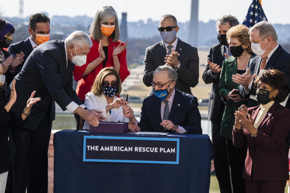 Speaker of the House Nancy Pelosi (D-Calif.) and Senate Majority Leader Chuck Schumer (D-N.Y.), center, sign the American Rescue Plan Act at a bill enrollment ceremony after the House passed the $1.9 trillion COVID-19 relief package on March 10. (Photo: Tom Williams via Getty Images)
