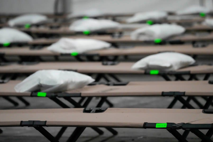 Green stickers indicate the row and place number of cots inside the dormitory tent during a media tour of a shelter New York City is setting up to house up to 1,000 migrants in the Queens borough of New York, Tuesday, Aug. 15, 2023. (AP Photo/Mary Altaffer, File)