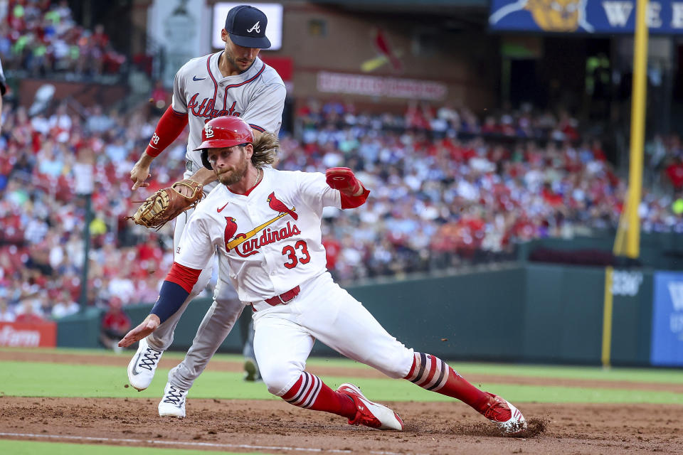 St. Louis Cardinals' Brendan Donovan (33) is tagged out by Atlanta Braves first baseman Matt Olson, top, after being caught in a rundown during the third inning of a baseball game Monday, June 24, 2024, in St. Louis. (AP Photo/Scott Kane)