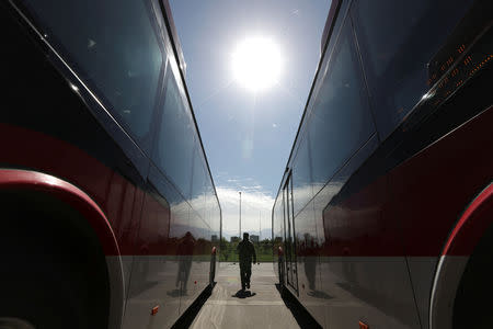 A man walks among electric buses as Chile's government launches the new fleet of electric buses for public transport in Santiago, Chile December 13, 2018. REUTERS/Ivan Alvarado