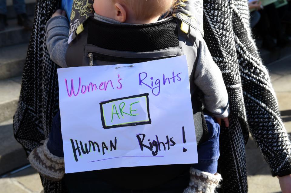 A woman carries a baby with a note fastened to the baby carrier and reading 'Women's rights are human rights!' during a rally in solidarity with the Women's March taking place in Washington and many other cities on January 21, 2017 in Bordeaux, Southwestern France.