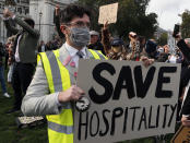 Hospitality workers protest in Parliament Square in London, Monday, Oct. 19, 2020. Hospitality workers are demonstrating outside Parliament against tougher coronavirus restrictions and the amount of financial support given by the government to the industry.(AP Photo/Frank Augstein)