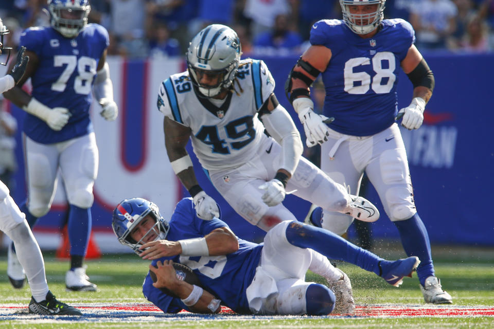 New York Giants quarterback Daniel Jones, bottom, slides after running for a first down during the second half an NFL football game against the Carolina Panthers, Sunday, Sept. 18, 2022, in East Rutherford, N.J. (AP Photo/John Munson)