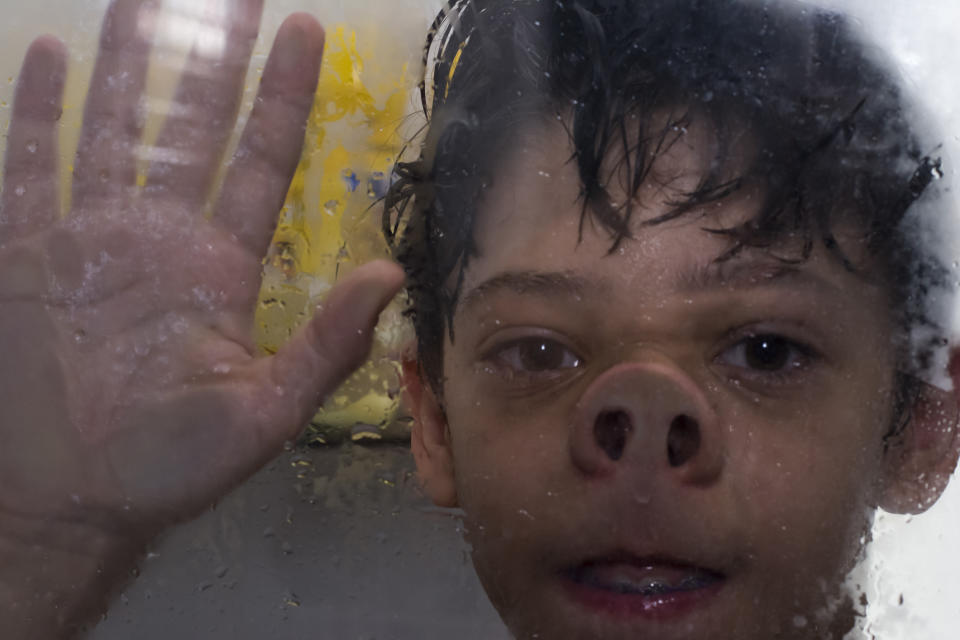 kid with face against shower