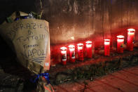 A note reading in Italian "Thanks for everything, signed Naples" as candles are placed to honor soccer legend Diego Maradona, in Naples, Italy, Wednesday, Nov. 25, 2020. Diego Maradona has died. The Argentine soccer great was among the best players ever and who led his country to the 1986 World Cup title before later struggling with cocaine use and obesity. He was 60. (Fabio Sasso/LaPresse via AP)