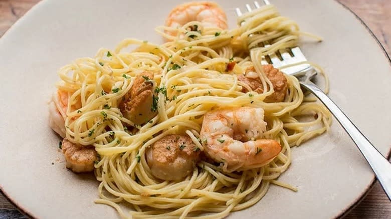 Shrimp, scallops, and shrimp pasta on a plate with a fork