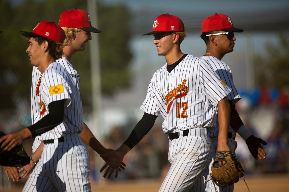 Centennial Hawks high five one another during a high school baseball game on Thursday, April 27, 2023, at the Field of Dreams. 