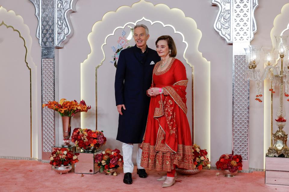 Former British Prime Minister Tony Blair and his wife Cherie Blair pose for photos