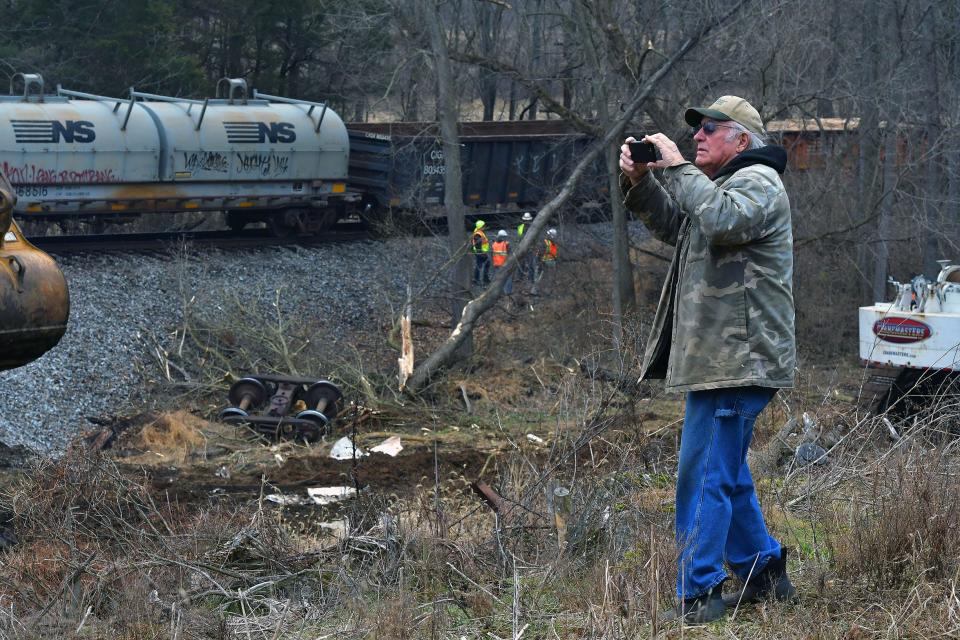 Tom Shaw uses his cellphone to take pictures of a Norfolk Southern train derailment near his home on Tommytown Road near Sharpsburg on Thursday. The railroad tracks run through his property. The derailment occurred Wednesday night.