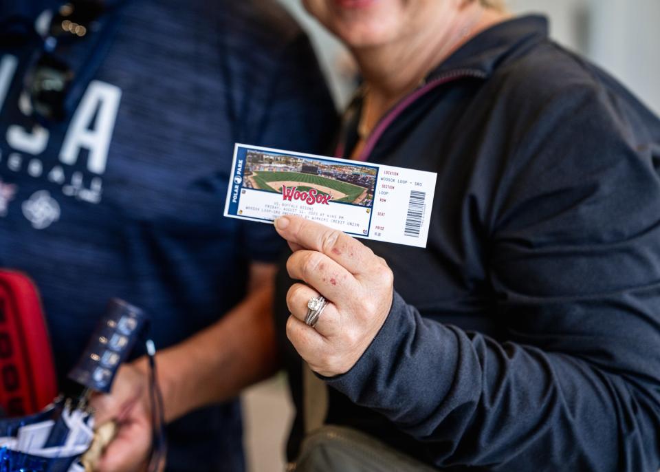 Noreen Akins holds a ticket for Friday's WooSox game at Polar Park. Her son, Liam, was the holder of the 500,000th ticket sold at Polar Park this season