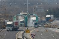 Vehicles leaving the Kaesong joint industrial zone pass through disinfectant spray before a checkpoint at the CIQ immigration centre near the Demilitarized Zone (DMZ) separating North and South Korea, in Paju on February 11, 2016