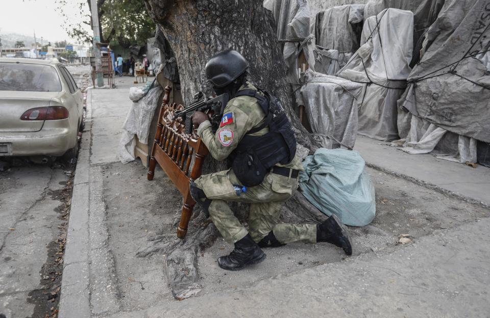 Police take cover during an anti-gang operation at the Portail neighborhood of Port-au-Prince, Haiti, Thursday, Feb. 29, 2024. Gunmen shot at the international airport and other targets in a wave of violence that forced businesses, government agencies and schools to close early. (AP Photo/Odelyn Joseph)