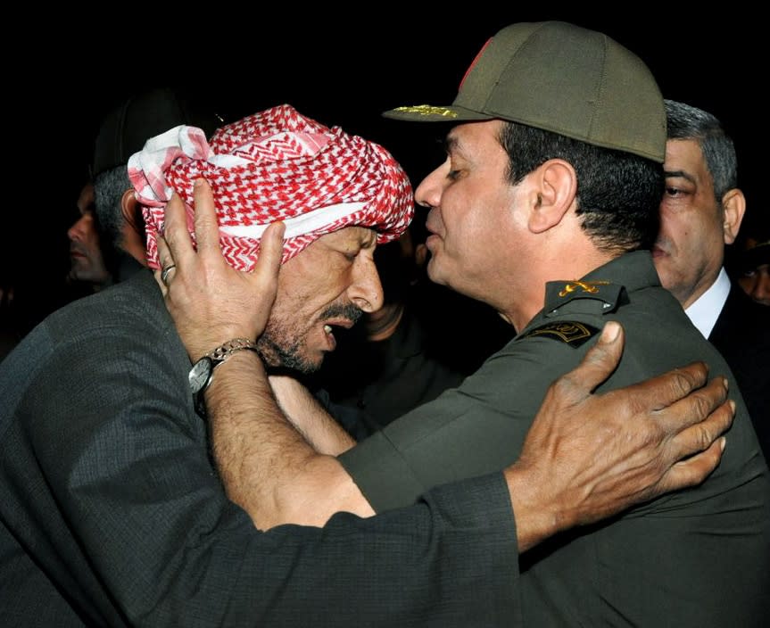 FILE - In this Nov. 20, 2013, file photo released on the official Facebook page of the Egyptian Military spokesman of the Armed Forces, Egyptian Defense Minister Gen. Abdel-Fattah el-Sissi, right, kisses the forehead of a relative of a 2nd Field Army solider who was killed after a suicide bomber rammed his explosive-laden car into one of two buses carrying off-duty soldiers, at the road between the border town of Rafah and the coastal city of el-Arish, during their funeral procession in Cairo. The head of Egypt’s military, Abdel-Fattah el-Sissi, is riding on a wave of popular fervor that is almost certain to carry him to election as president. Unknown only two years ago, a broad sector of Egyptians now hail him as the nation’s savior after he ousted the Islamists from power, and the state-backed personality cult around him is so eclipsing, it may be difficult to find a candidate to oppose him if he runs. Still, if he becomes president, he faces the tough job of ruling a deeply divided nation that has already turned against two leaders.(AP Photo/The Official Facebook Page of the Egyptian Military spokesman of the Armed Forces, File)