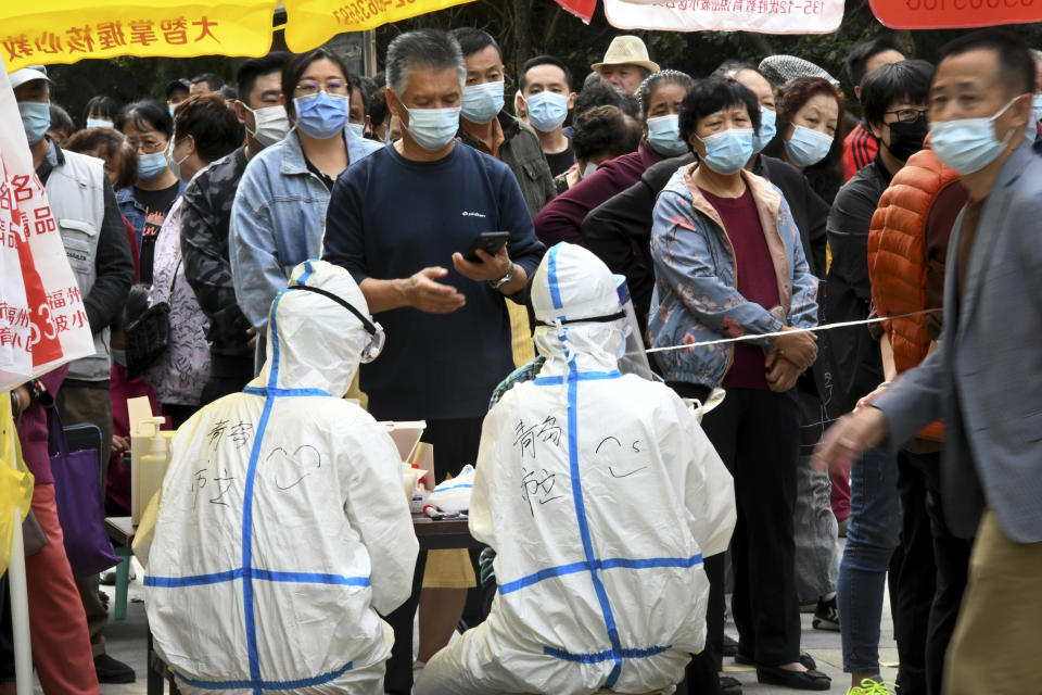 In this photo released by Xinhua News Agency, residents wearing face masks to help curb the spread of the coronavirus line up for the COVID-19 test near the residential area in Qingdao in east China's Shandong province on Tuesday, Oct. 13, 2020. China says it has carried out more than 4.2 million tests in the northern port city of Qingdao, with no new cases of coronavirus found among the almost 2 million sets of results received. (Li Ziheng/Xinhua via AP)