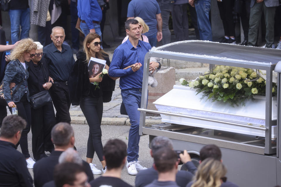 Parents of Ema Kobiljski, 13, mourn during the funeral procession at the central cemetery in Belgrade, Serbia, Saturday, May 6, 2023. Her schoolmate, a 13-year-old boy, on Wednesday, used his father's guns to kill eight fellow students and a guard. (AP Photo/Armin Durgut)