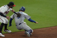 Los Angeles Dodgers' Chris Taylor (3) is tagged out by Atlanta Braves shortstop Dansby Swanson after being caught in a run down on base hit by Dodgers' Cody Bellinger during the ninth inning in Game 1 of baseball's National League Championship Series Saturday, Oct. 16, 2021, in Atlanta. (AP Photo/John Bazemore)